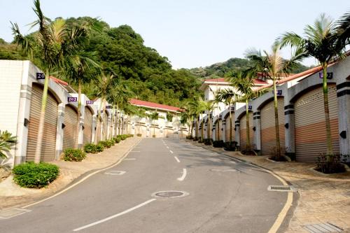 an empty street with palm trees and buildings at Regale Motel in Zhonghe