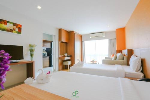 a large hotel room with two beds and a kitchen at Crystal Jade Hotel in Rayong