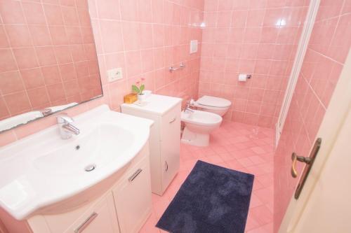 ポルトフェッラーイオにあるLe Salineのピンクのバスルーム(シンク、トイレ付)