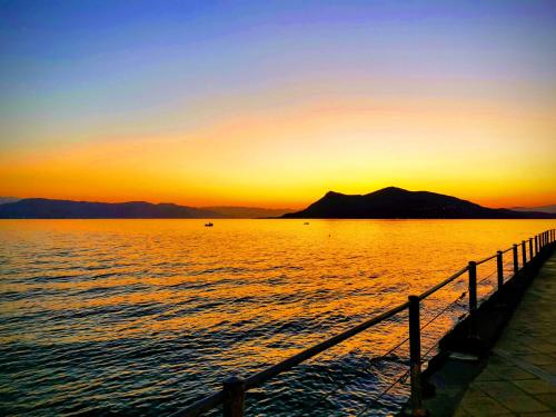 a sunset over a body of water with a pier at Hotel Rania in Loutra Edipsou