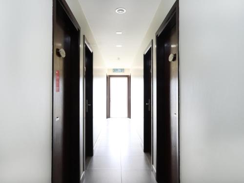 a hallway with black doors and white walls at Sunrise Golden Hotel in Kajang
