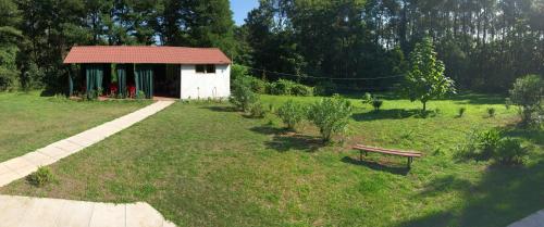 a park with a shed and a bench in the grass at Private Cottage at the Black sea in Shekvetili