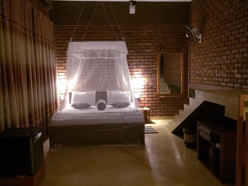 sypialnia z łóżkiem w ceglanej ścianie w obiekcie The Rezt w mieście Ella