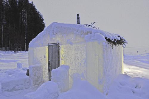 an ice house is covered in snow at Herranniemi Guesthouse in Vuonislahti
