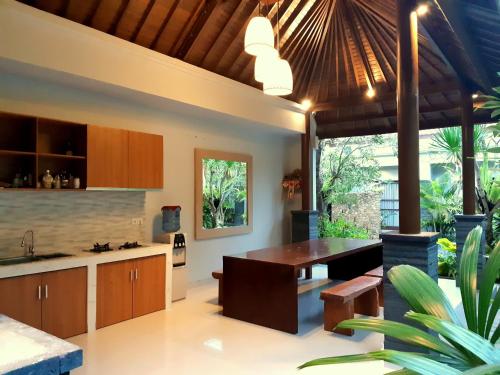 a kitchen with wooden cabinets and a dining table at The New Moon Seminyak in Seminyak