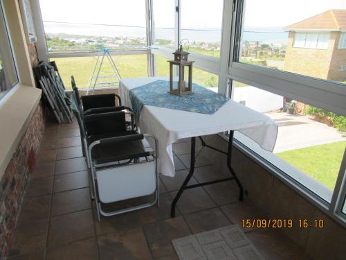 a table and chairs in a room with windows at Lewensdroom Self Catering in Tergniet