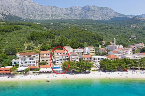 an aerial view of a beach with a red circle at Apartments Ratac in Tučepi