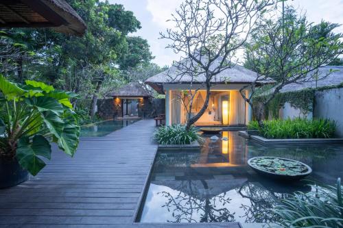 a house with a pond in the middle of a garden at Kayumanis Nusa Dua Private Villa & Spa in Nusa Dua