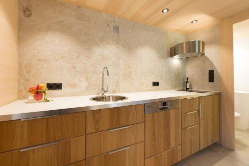 eine Küche mit Holzschränken und einem Waschbecken in der Unterkunft Gartenstudio Waldblick in Schwarzenberg im Bregenzerwald