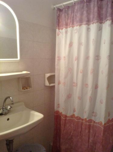 a bathroom with a shower curtain and a sink at Mpaliaka Myrsini in Mythimna
