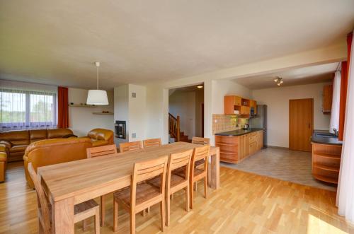 a kitchen and living room with a wooden table and chairs at Amenity Hotel & Resort Česká Kanada in Nová Bystřice