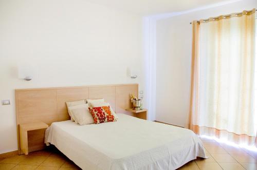 a bedroom with a white bed with a wooden headboard at Hotel Garden in Praia a Mare