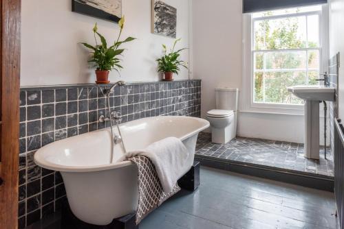 a bathroom with a tub and a sink at 144 Lower Cheltenham Place in Bristol
