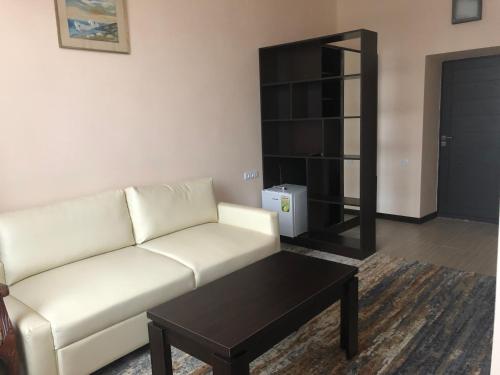 a living room with a white couch and a coffee table at Vanadzor Armenia Hotel in Vanadzor
