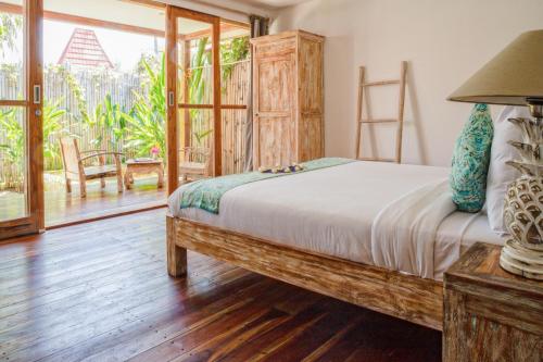 Un dormitorio con una cama y una ventana grande. en United Colors of Gili, en Gili Meno