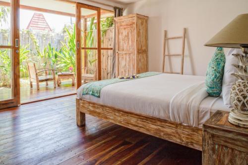 a bedroom with a bed and a large window at United Colors of Gili in Gili Meno