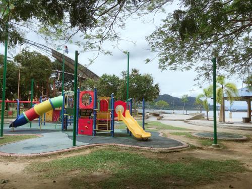 a playground with a slide in a park at Dindings Pantai Desair Apartment By DPD in Lumut