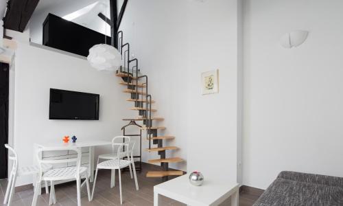 a living room with a spiral staircase and a table and chairs at Kollmann Rooms and Apartments in Ljubljana
