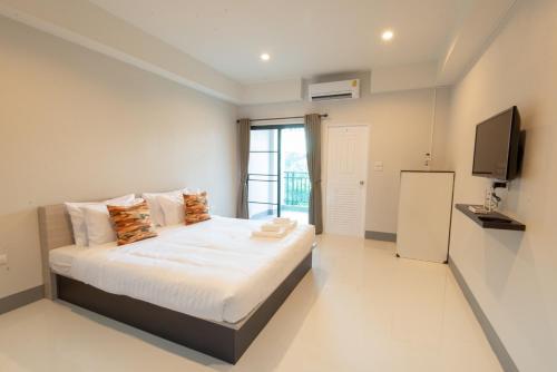 a bedroom with a bed and a television in it at J2 Residence Chiang Rai in Chiang Rai