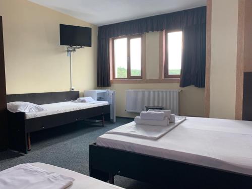 a room with two beds and a flat screen tv at Hotel Monte Carlo in Piteşti