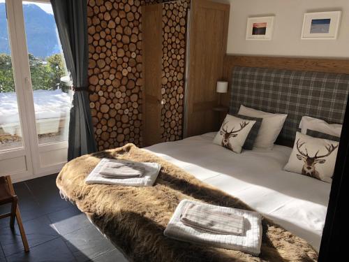 1 dormitorio con 1 cama con manta y ventana en Marelle Apartment, Verbier, en Verbier