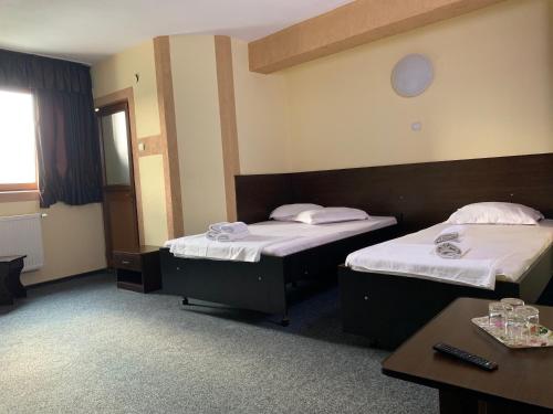 a hotel room with two beds and a table at Hotel Monte Carlo in Piteşti