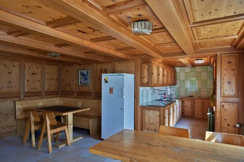 cocina con armarios de madera y nevera blanca en Aktivhostel HängeMatt, en Matt