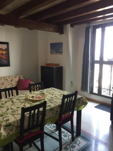 シラクーサにあるTolomei House Holidays Sea Viewのテーブルと椅子とソファのあるダイニングルーム