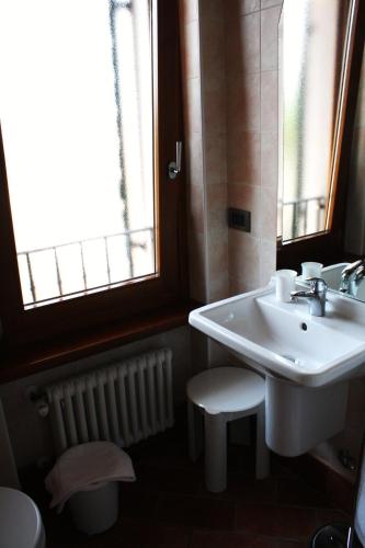 a bathroom with a sink and a toilet and windows at Bed&Wine in Negrar