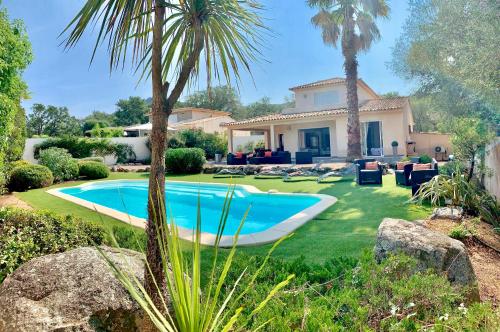 une maison avec une piscine dans une cour dans l'établissement Villa CASAMIRAFIO à PALOMBAGGIA piscine chauffée et 8 à 9 personnes, à Porto-Vecchio