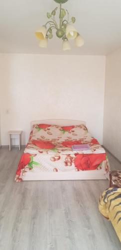 a bedroom with a bed with flowers on it at Apartment Vosstania Square in Gomel