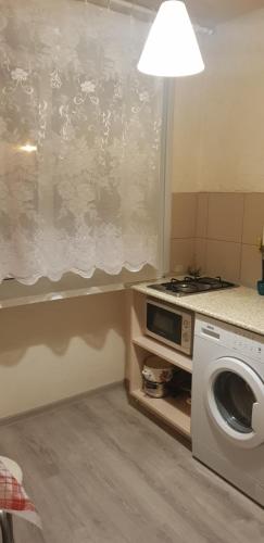 a kitchen with a stove and a washing machine at Apartment Vosstania Square in Gomel