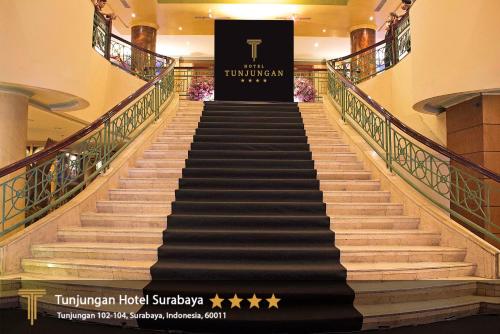 a set of stairs in a hotel with a sign at Tunjungan Hotel in Surabaya
