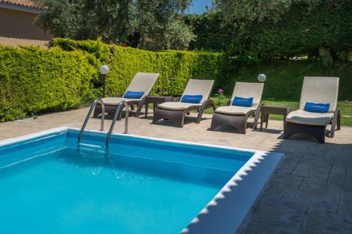 a group of chairs and a swimming pool at Hotel St John Villas in Tsilivi