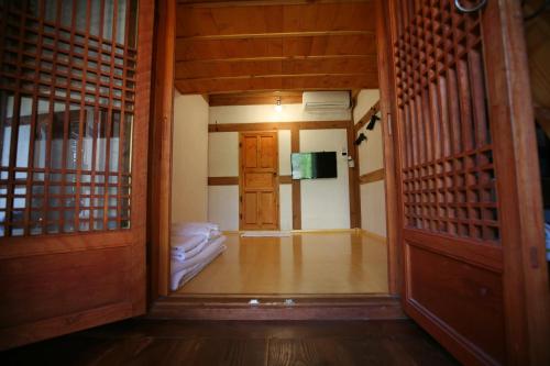 a hallway with a door and a room with a bed at GaEunChae 2 in Jeonju