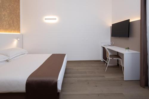 a bedroom with a bed and a desk with a computer at Best Western Hotel Biri in Padova