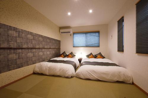two beds sitting next to each other in a room at Ixyz杜 in Nagoya