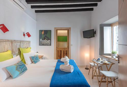 a bedroom with a large white bed and a table at Tribeca b&b Boutique in Marbella