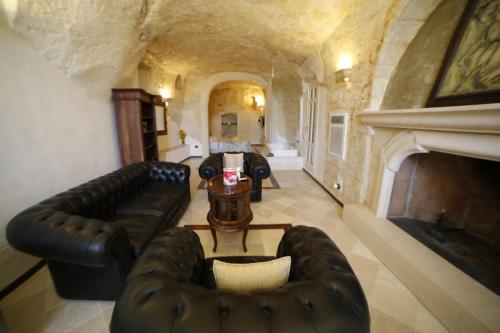 a living room with leather furniture and a fireplace at Alla dimora di Chiara Suite and Rooms in Matera
