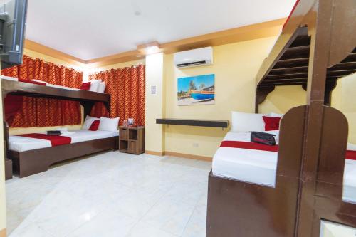 a bedroom with two bunk beds and a tv at RedDoorz near Notre Dame of Dadiangas University in General Santos