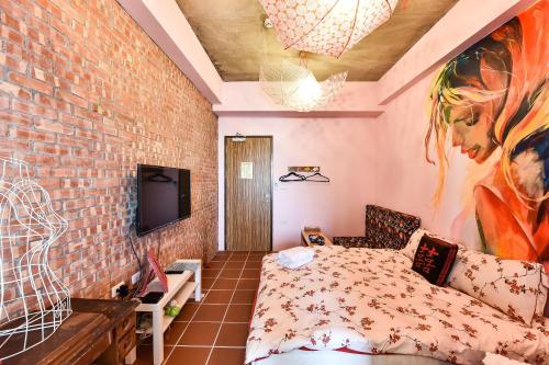 a room with a bed and a brick wall at Anping Wikid Design Hotel in Tainan