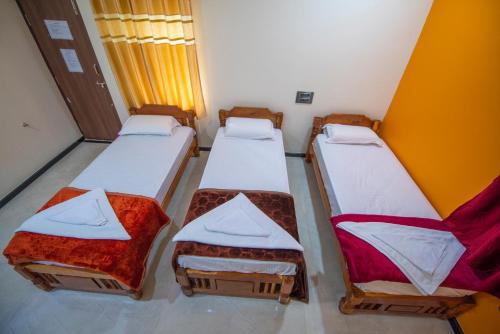 a group of three beds in a room at Arjun Homestay in Hampi