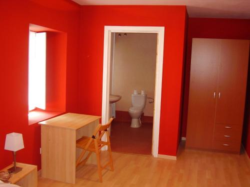 a bathroom with red walls and a toilet at Casa Rural Ortulane in Urduliz