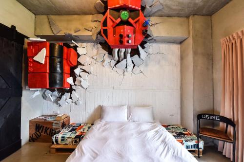 a bedroom with a bed and a red robot on the wall at Anping Wikid Design Hotel in Tainan
