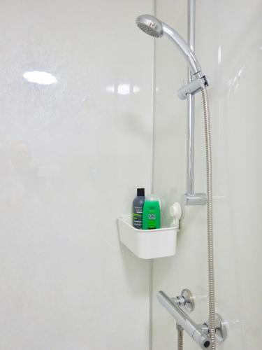 a shower with a shower head in a bathroom at Reading Serviced Rooms in Reading