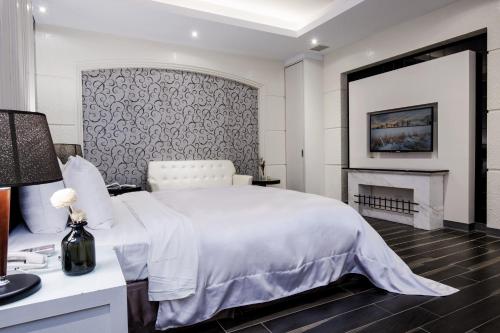 a bedroom with a white bed and a fireplace at Duo Romance Hotel in Hualien City