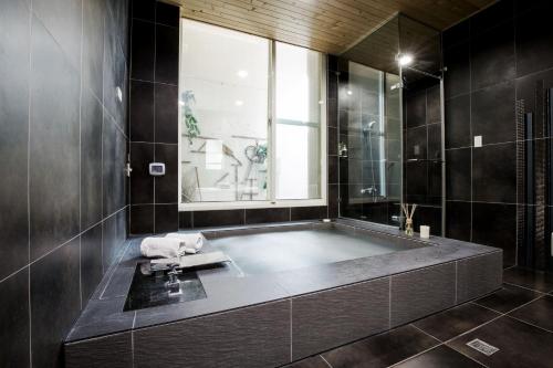 a bathroom with a bath tub with a window at Duo Romance Hotel in Hualien City