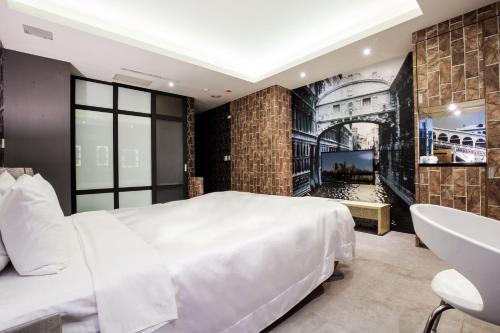a bedroom with a large white bed and a sink at Duo Romance Hotel in Hualien City