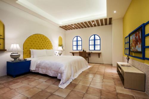 a bedroom with a large bed and two windows at Duo Romance Hotel in Hualien City