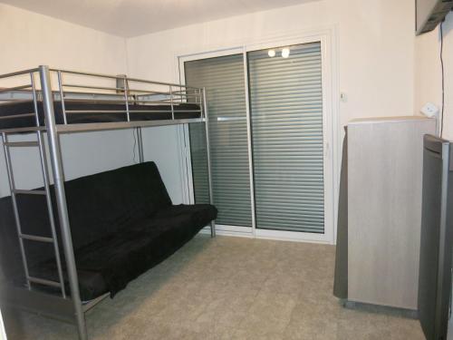 un salon avec un lit superposé et un canapé dans l'établissement Joli studio A front de mer, à Saint-Raphaël